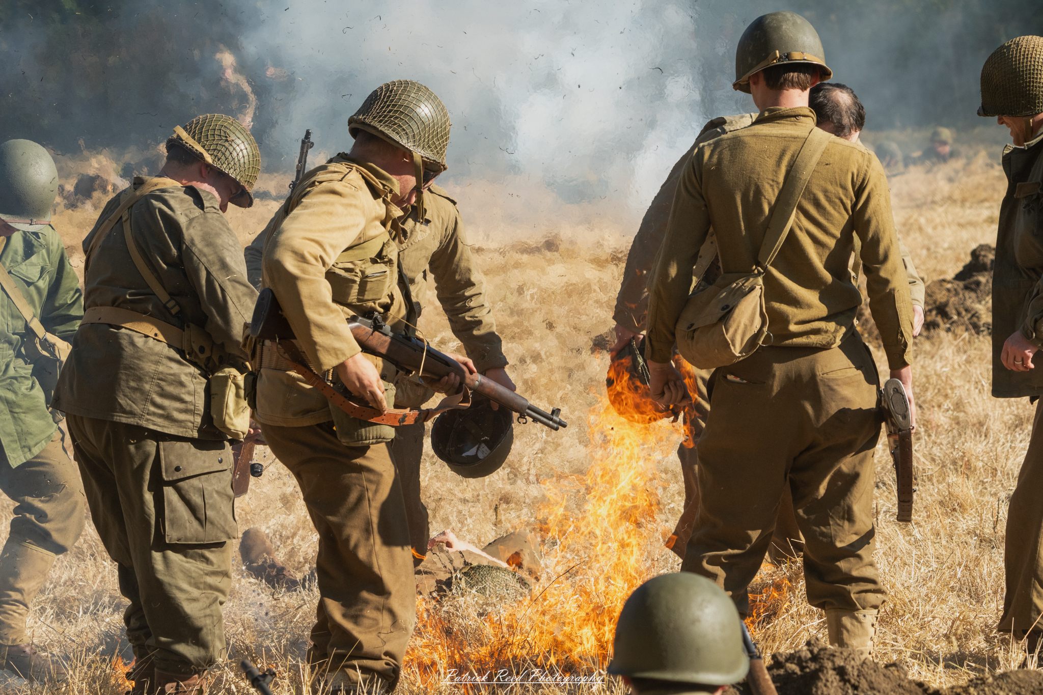 "Scene depicting a field engulfed in flames with soldiers actively using canteens to combat the fire. The soldiers, wearing military uniforms, are pouring water from their canteens onto the flames in a desperate attempt to extinguish the blaze. Smoke billows into the sky, creating a dramatic contrast against the vibrant flames, highlighting the bravery and resourcefulness of the soldiers in this intense situation."